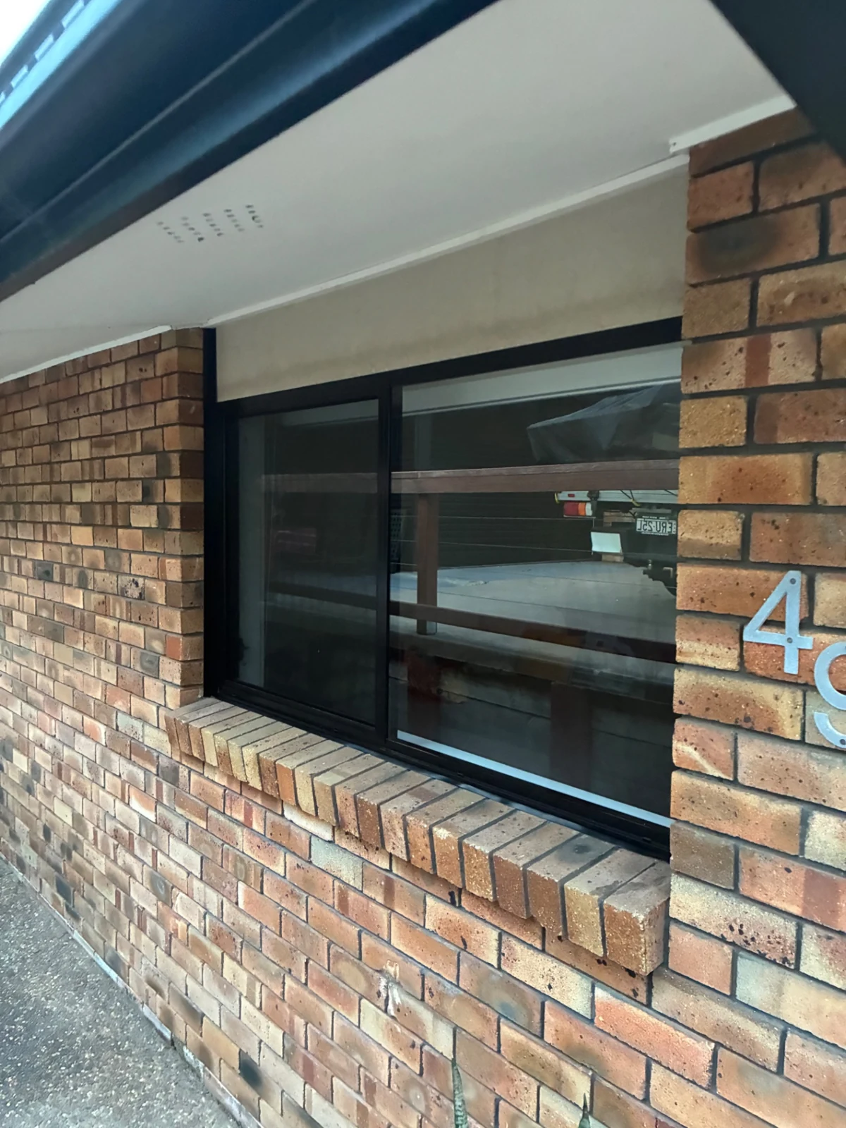 Close view of a black-framed window fitted into a brick wall